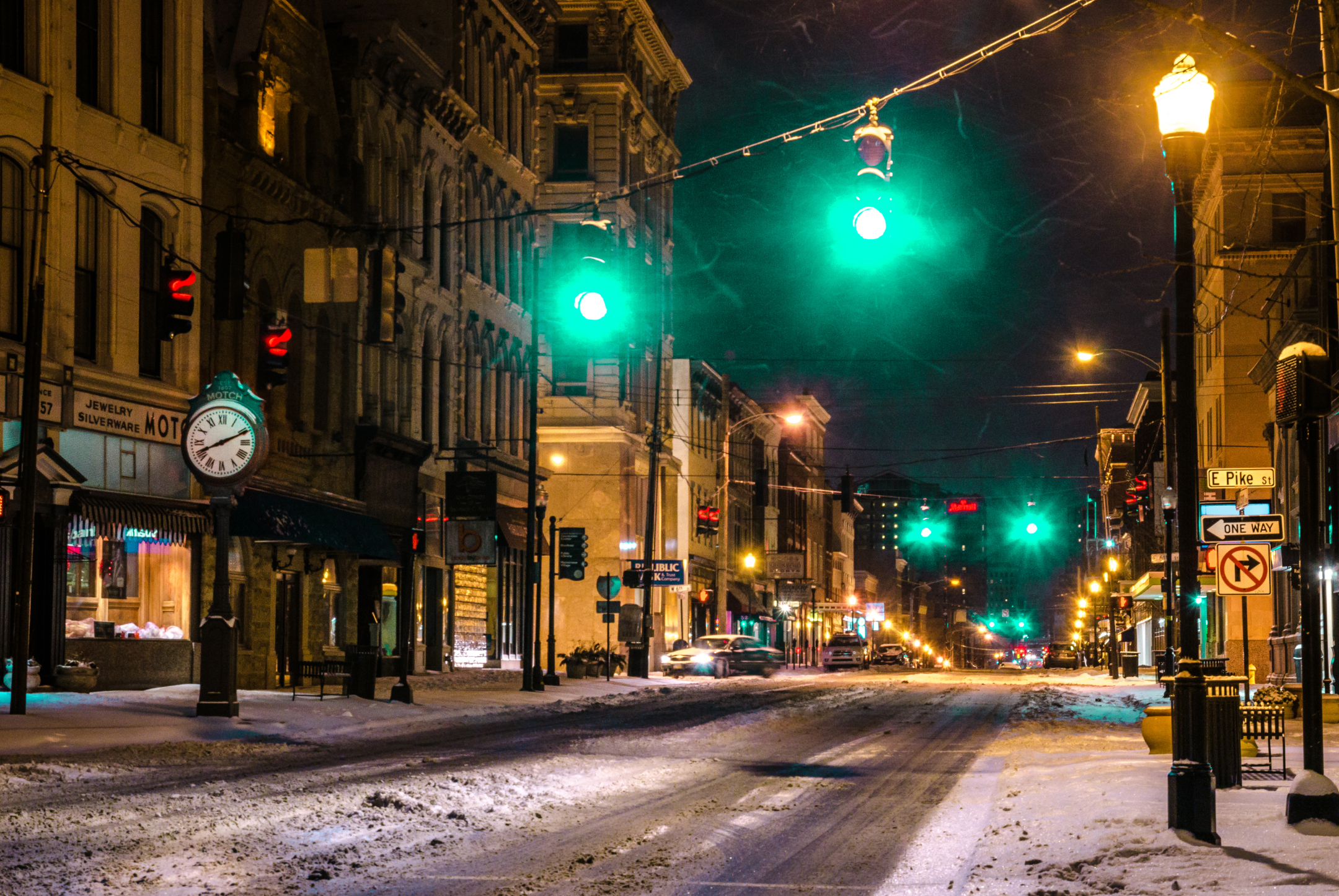 Snowy city street at night